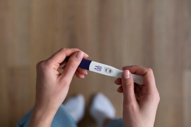 Woman holding a positive pregnancy test while checking the result