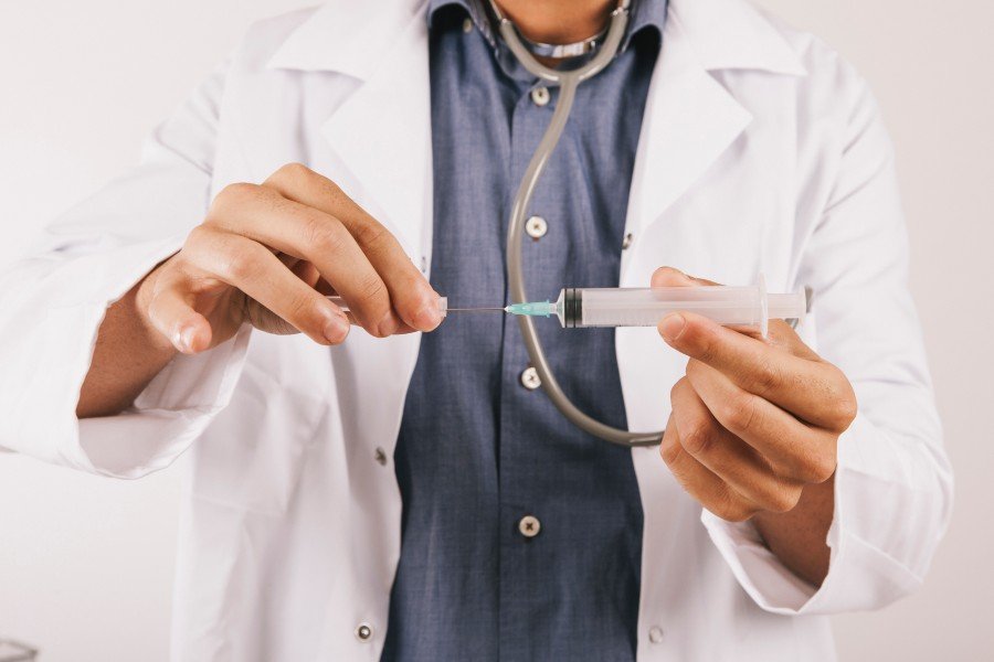Doctor holding a syringe during a medical procedure related to Urine problem treatment