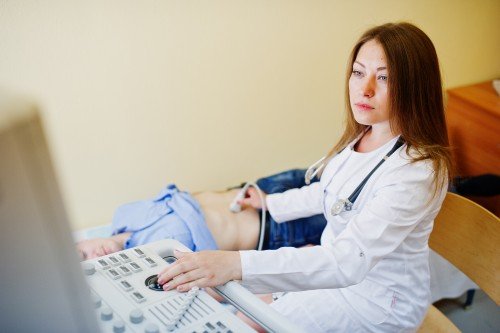 Gynecologist performing an ultrasound examination on a patient in a Gynecology Clinic.